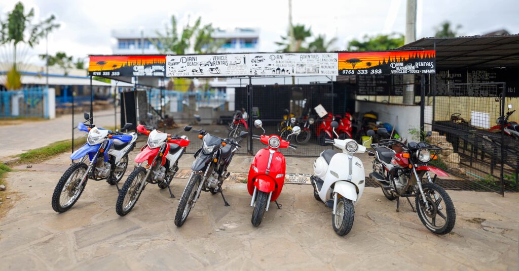 a variety of motorbike rentals parked outside diani beach vehicle rentals office